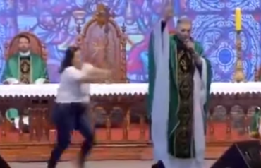 woman shoves priest