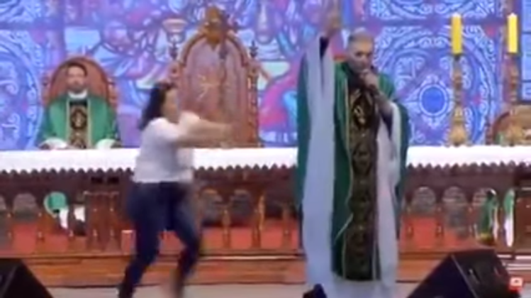 woman shoves priest